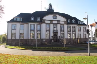 P&uuml;ttlingen: Rathaus mit Stra&szlig;enlaternen und Gr&uuml;nfl&auml;che.