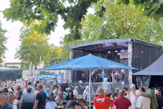 Besucher eines Feste im Vordergrund. B&uuml;hne im Hintergrund.